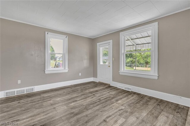 unfurnished room with hardwood / wood-style flooring and crown molding