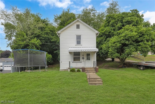 view of front of house with a trampoline and a front lawn