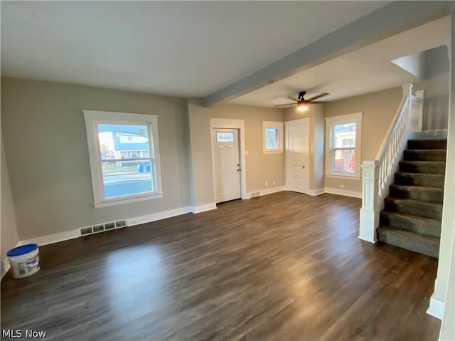 interior space with ceiling fan, beam ceiling, dark wood-type flooring, and a healthy amount of sunlight