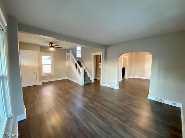 unfurnished living room with ceiling fan and dark hardwood / wood-style flooring