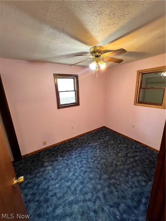 carpeted spare room with a textured ceiling and ceiling fan