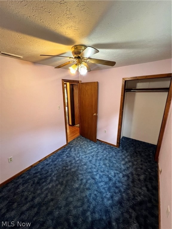 unfurnished bedroom featuring a closet, carpet, a textured ceiling, and ceiling fan