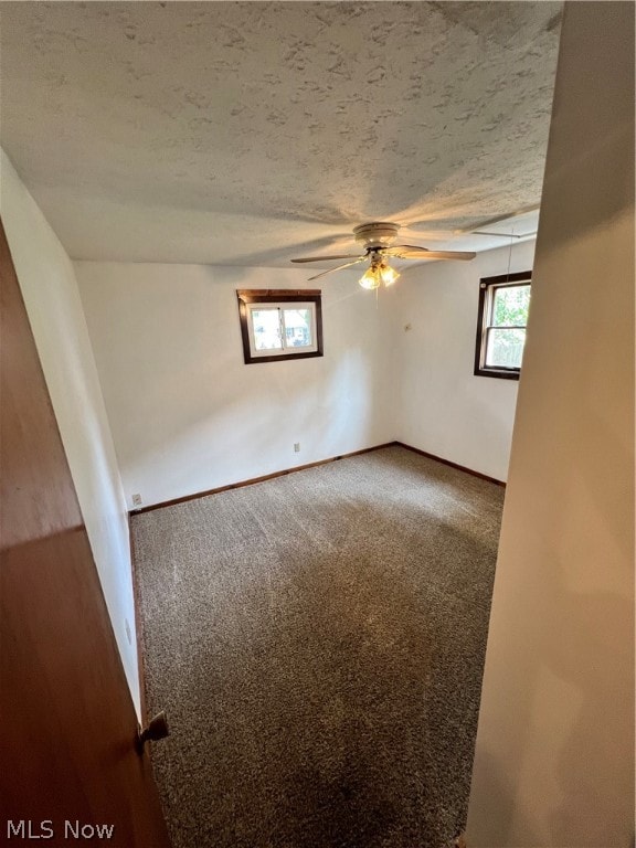 carpeted empty room with a textured ceiling