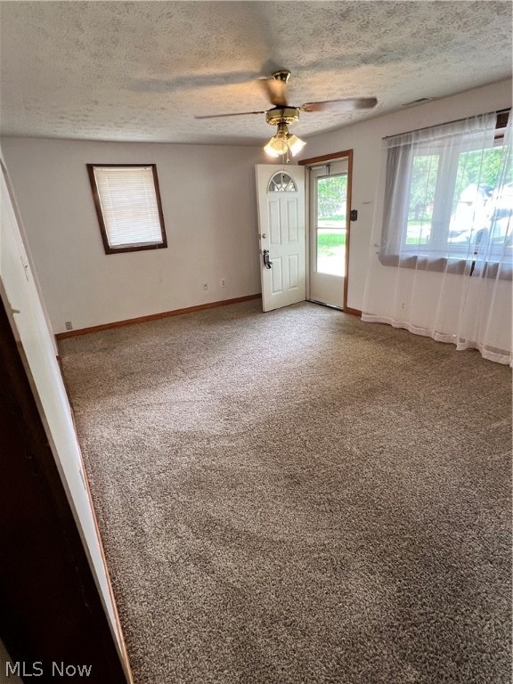 carpeted spare room with a textured ceiling and ceiling fan