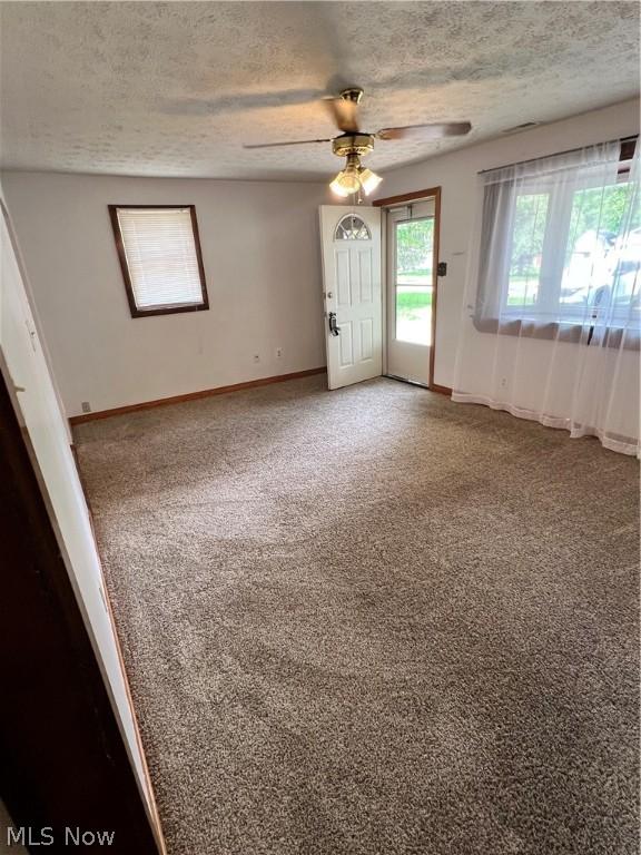 unfurnished room with carpet, a textured ceiling, and ceiling fan