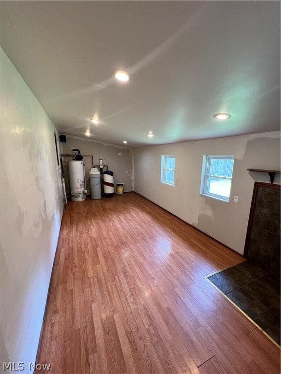 unfurnished living room with hardwood / wood-style flooring and gas water heater