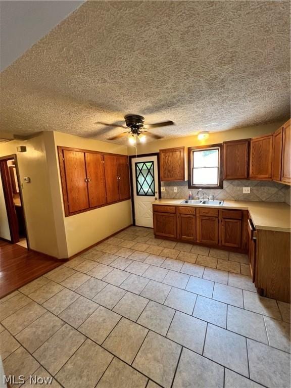 kitchen featuring sink, decorative backsplash, ceiling fan, and light tile patterned flooring