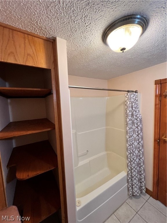 bathroom with a textured ceiling, shower / bath combo, and tile patterned flooring