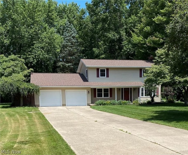 view of property with a garage and a front lawn