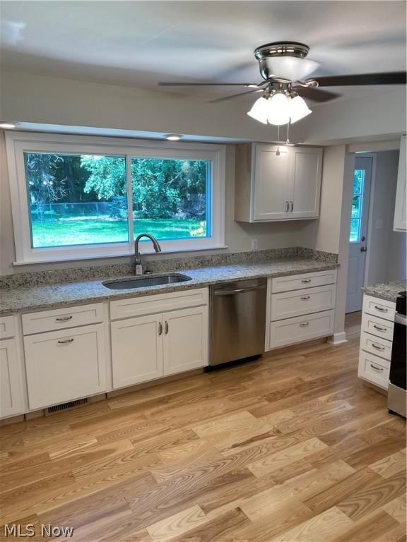 kitchen with sink, stainless steel dishwasher, ceiling fan, light wood-type flooring, and white cabinetry