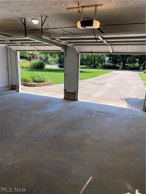 garage featuring a lawn and a garage door opener