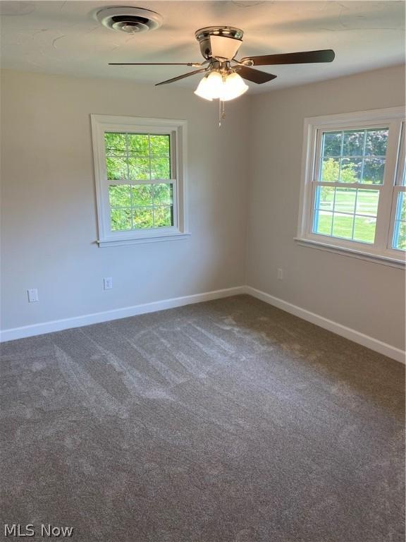 carpeted spare room featuring ceiling fan