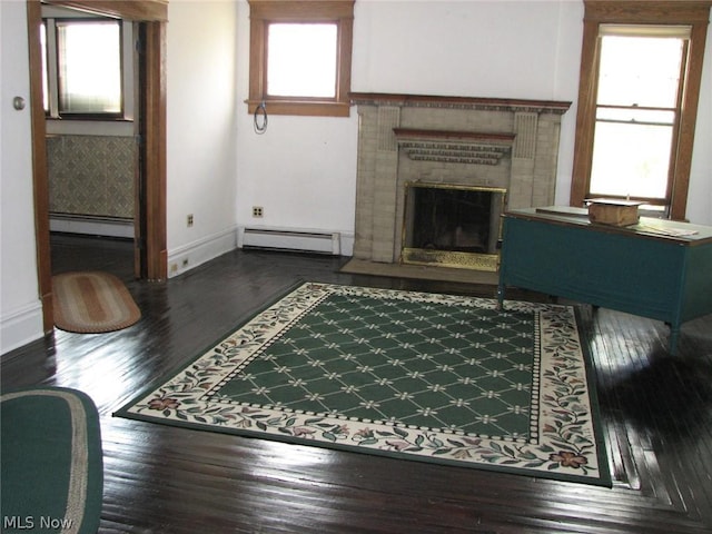 unfurnished living room featuring dark hardwood / wood-style floors, a fireplace, and a baseboard radiator