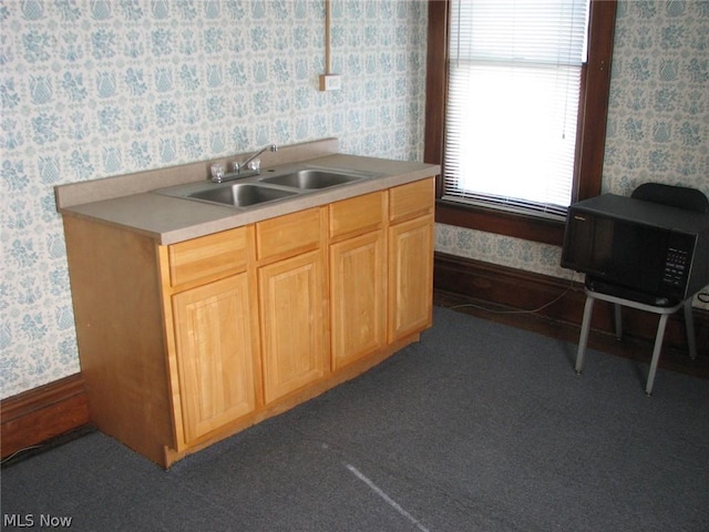 kitchen featuring sink, light brown cabinets, and dark colored carpet