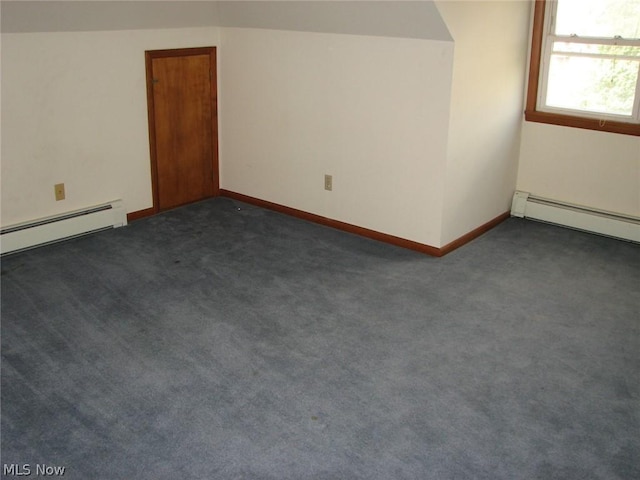 unfurnished room with dark carpet, baseboard heating, and vaulted ceiling