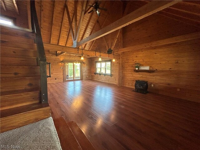 unfurnished living room with wood ceiling, hardwood / wood-style flooring, a wood stove, wooden walls, and beamed ceiling