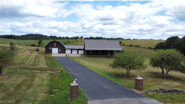 view of front of house with a front yard and a rural view