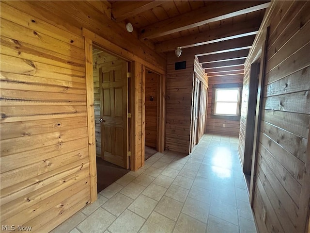 hall featuring wood ceiling, beam ceiling, wooden walls, and light tile patterned flooring