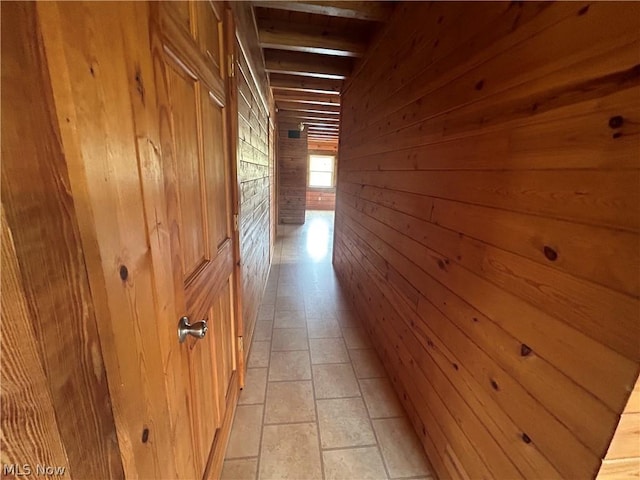 corridor featuring wooden walls and light tile patterned flooring