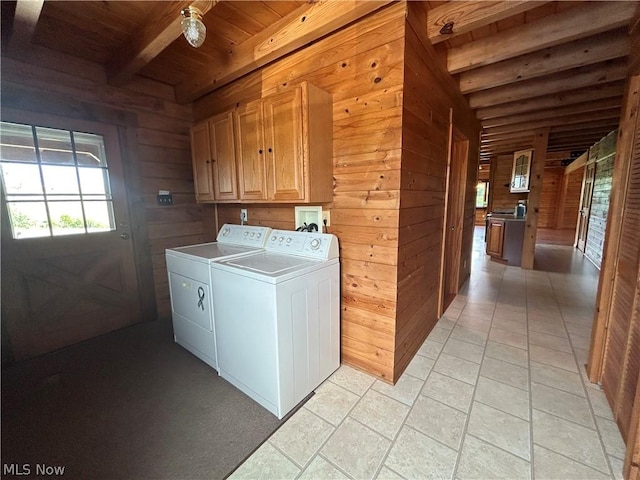 washroom with wood ceiling, wooden walls, cabinets, and washing machine and clothes dryer