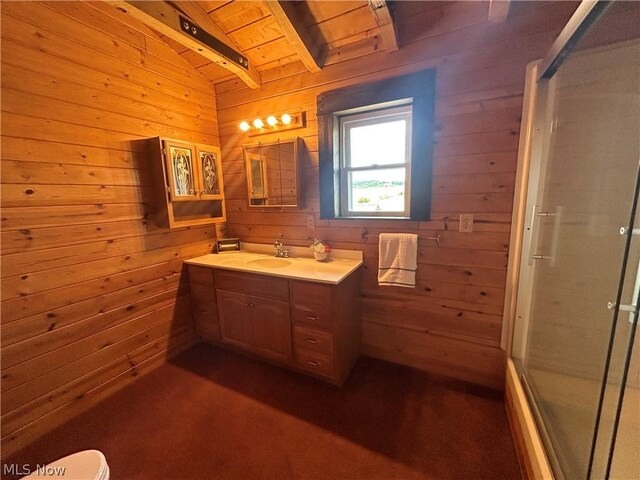 bathroom featuring vanity, beam ceiling, a shower with door, and wood walls