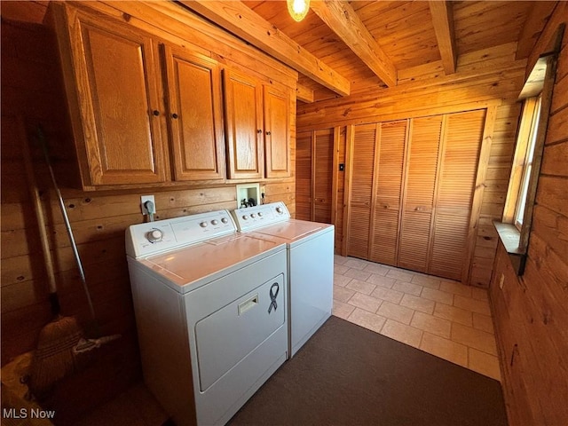 laundry room featuring wood ceiling, washer and clothes dryer, cabinets, light tile patterned flooring, and wood walls