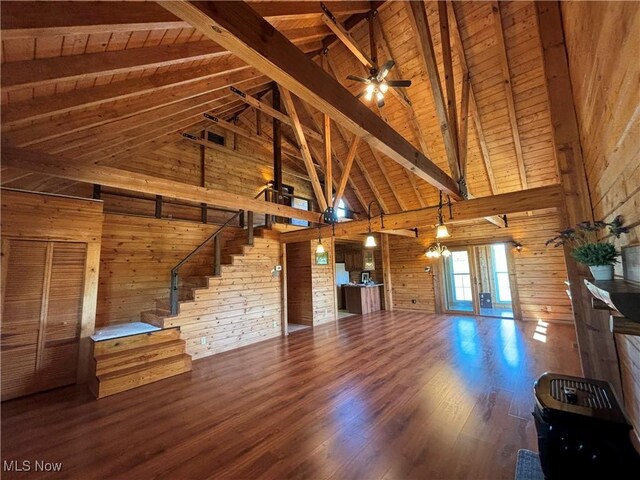 unfurnished living room featuring ceiling fan, hardwood / wood-style floors, beam ceiling, wooden ceiling, and wood walls