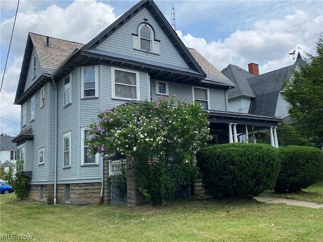 rear view of property featuring a yard