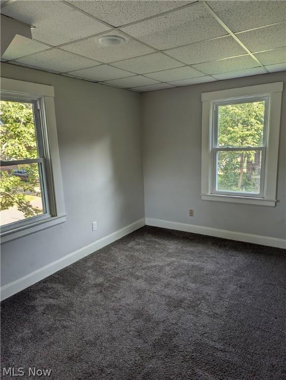 carpeted spare room featuring a paneled ceiling