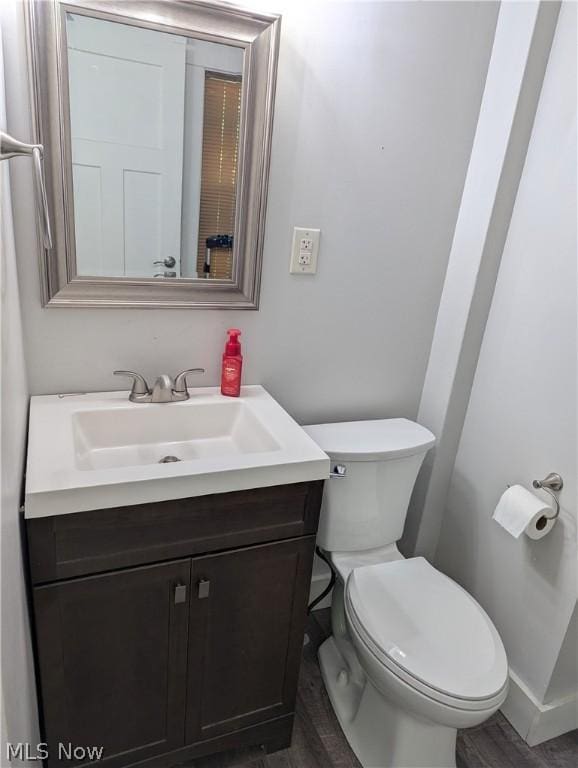 bathroom with toilet, wood-type flooring, and vanity