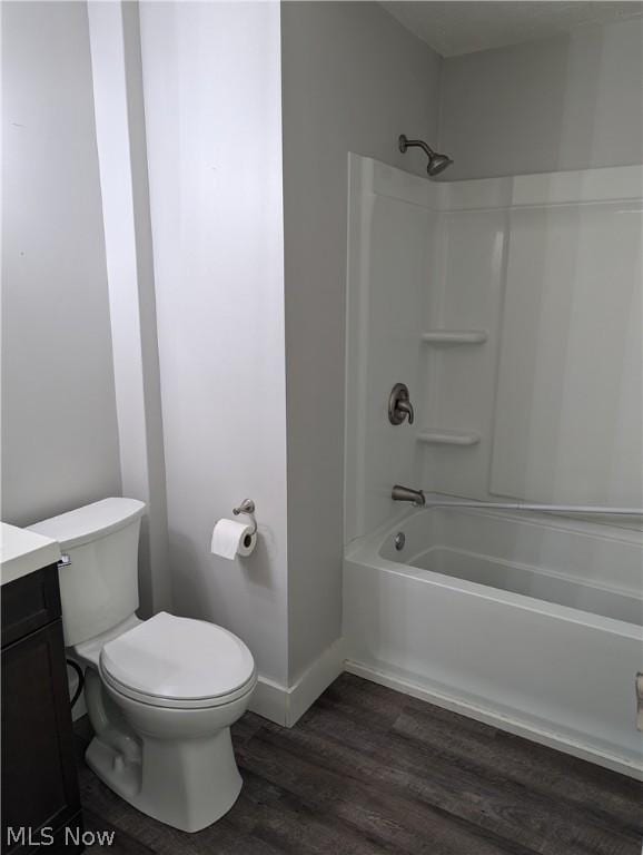 full bathroom featuring hardwood / wood-style floors, shower / bath combination, toilet, and vanity