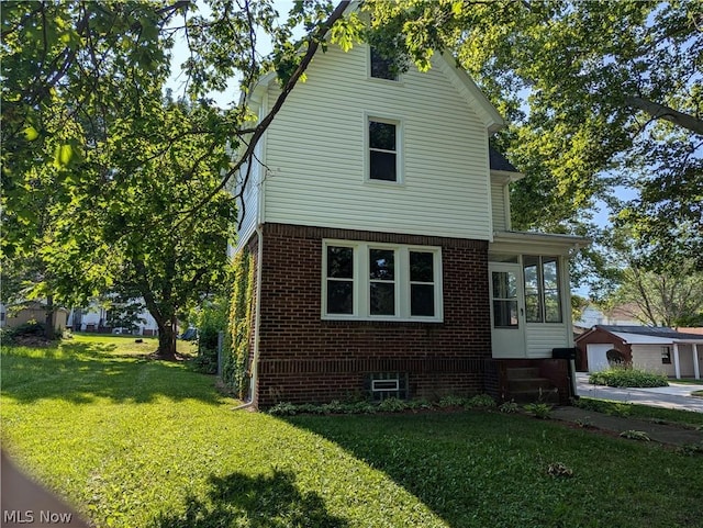 view of side of home with a yard