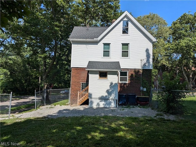 rear view of house featuring a lawn