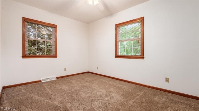 carpeted spare room with ceiling fan