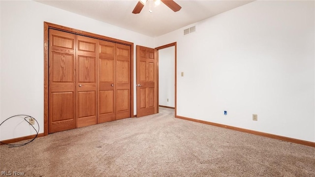 unfurnished bedroom featuring light colored carpet, a closet, and ceiling fan