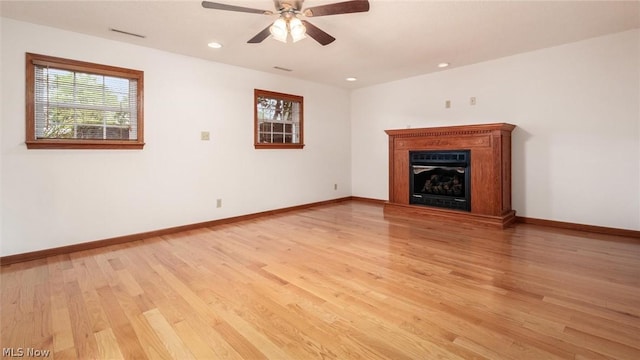 unfurnished living room with ceiling fan, a healthy amount of sunlight, and light wood-type flooring