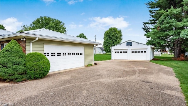 view of home's exterior with a garage and an outbuilding