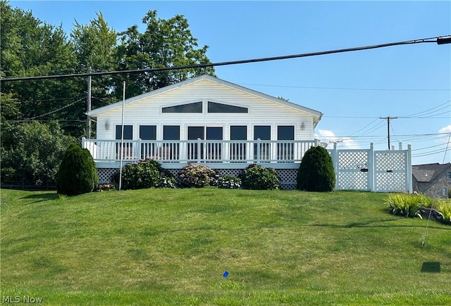 view of front of property with a front yard and a deck