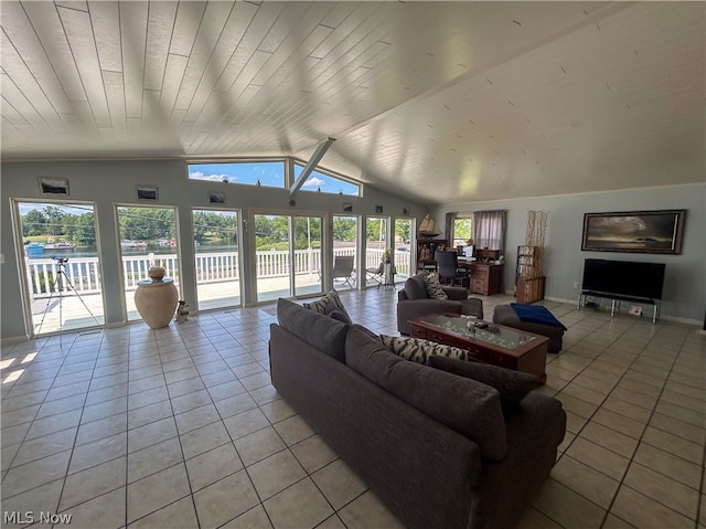 living room featuring light tile patterned flooring, vaulted ceiling, and a wealth of natural light