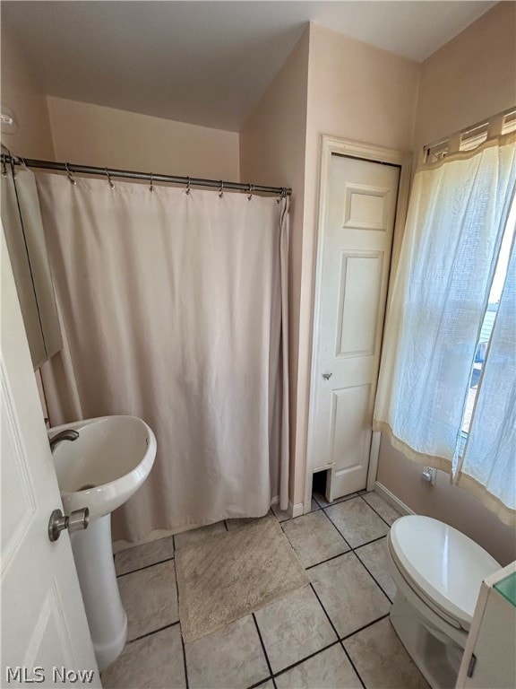 bathroom featuring toilet and tile patterned flooring