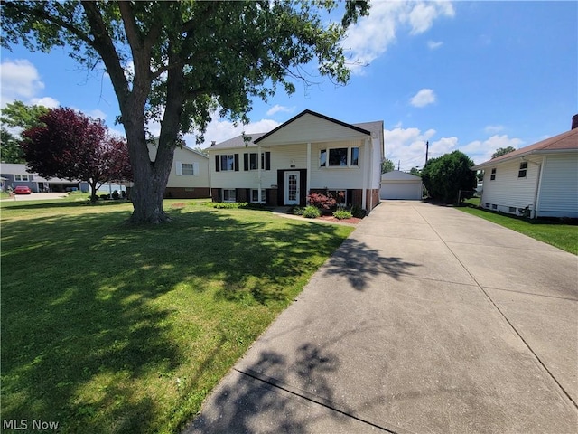 raised ranch with a garage, an outbuilding, and a front yard