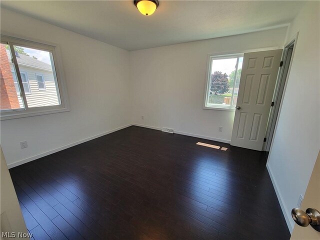 empty room with dark wood-type flooring