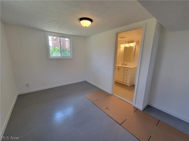 empty room with a textured ceiling and sink