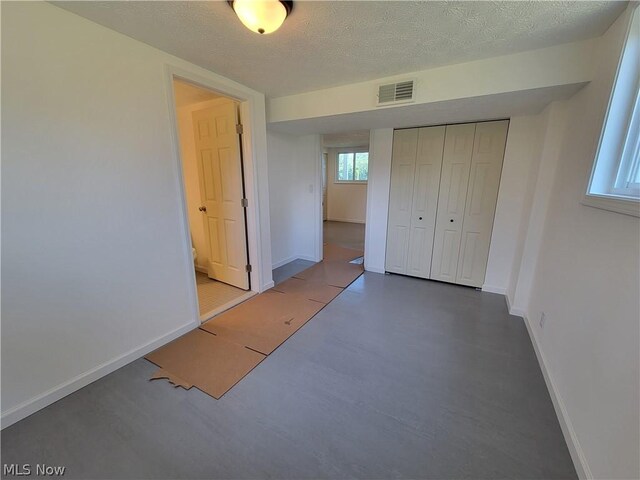 unfurnished bedroom with a textured ceiling and a closet