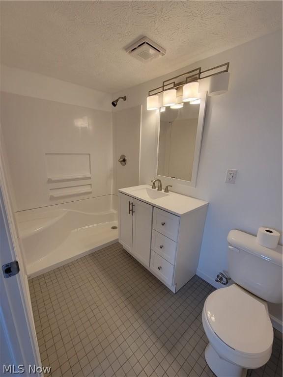 bathroom featuring vanity, a textured ceiling, and toilet