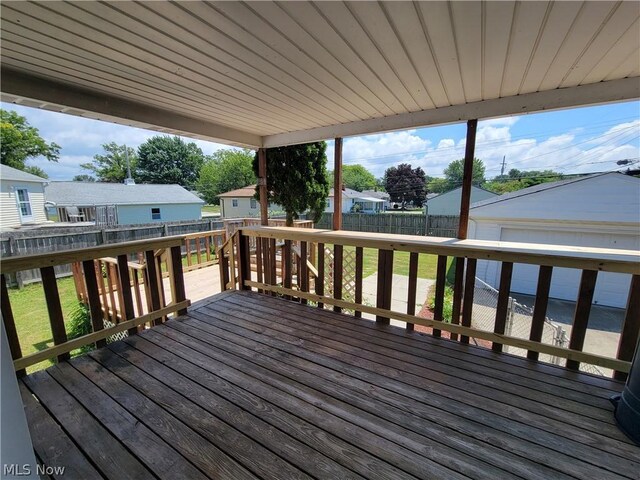 wooden deck with a garage and an outbuilding