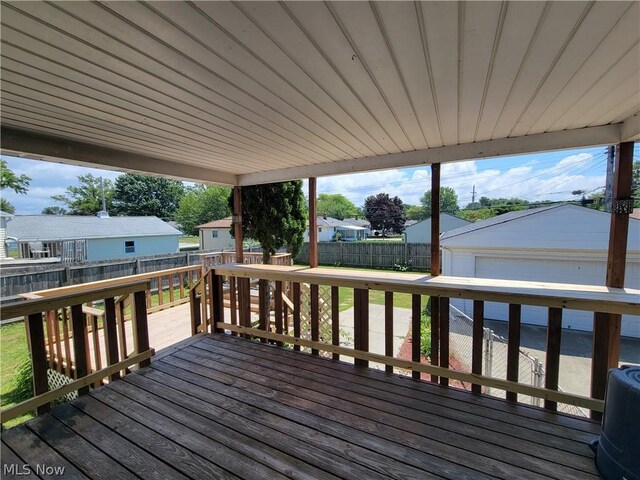 wooden terrace with central air condition unit, an outdoor structure, and a garage