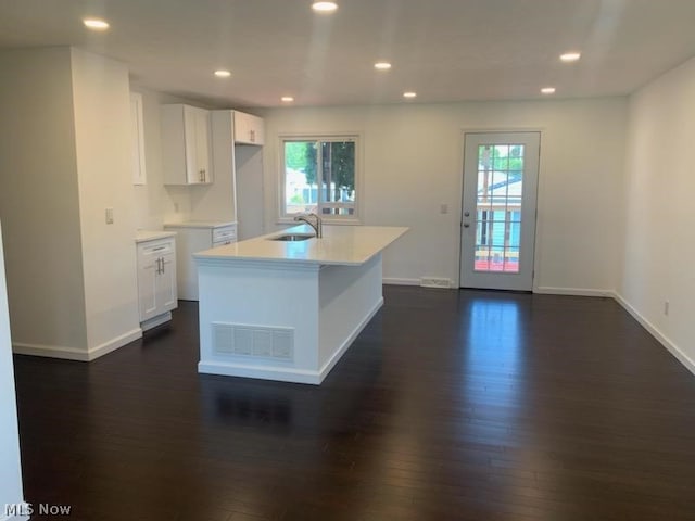 kitchen with white cabinetry, sink, an island with sink, and a healthy amount of sunlight