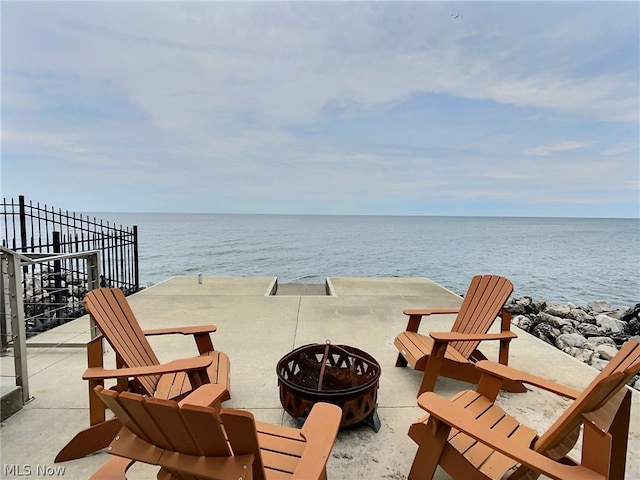 view of patio with a water view and a fire pit