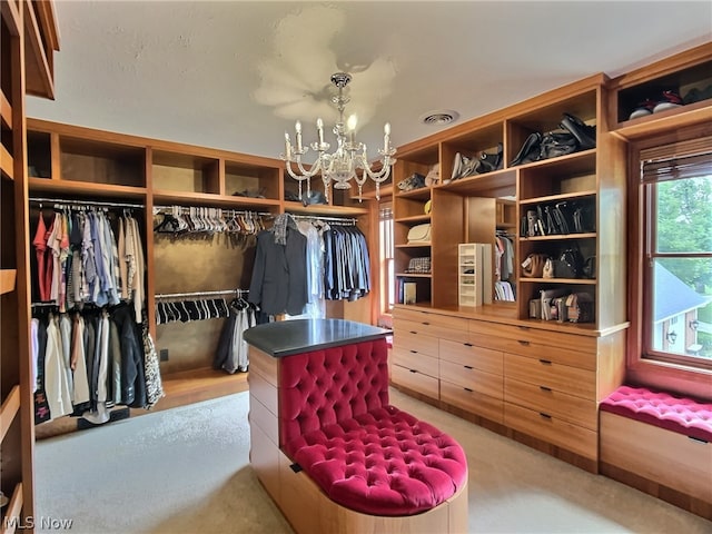 walk in closet with an inviting chandelier and carpet